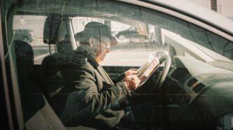 man in black jacket driving car