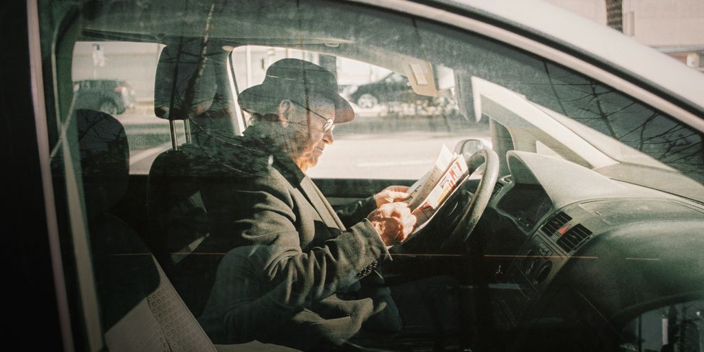 man in black jacket driving car